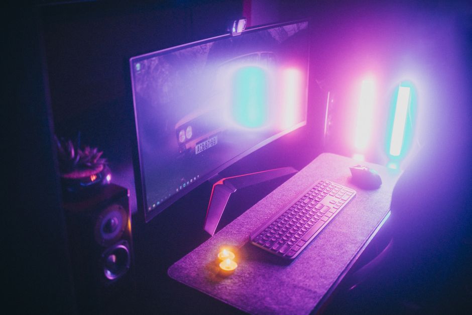A stylish gaming desk featuring neon lights, keyboard, and monitor