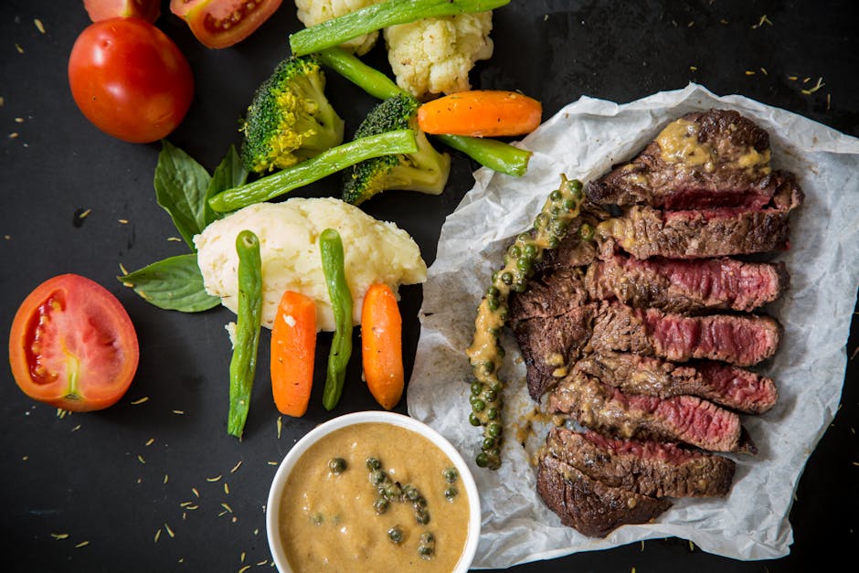 Grilled steak served with fresh vegetables and pepper sauce, presenting a colorful and appetizing meal